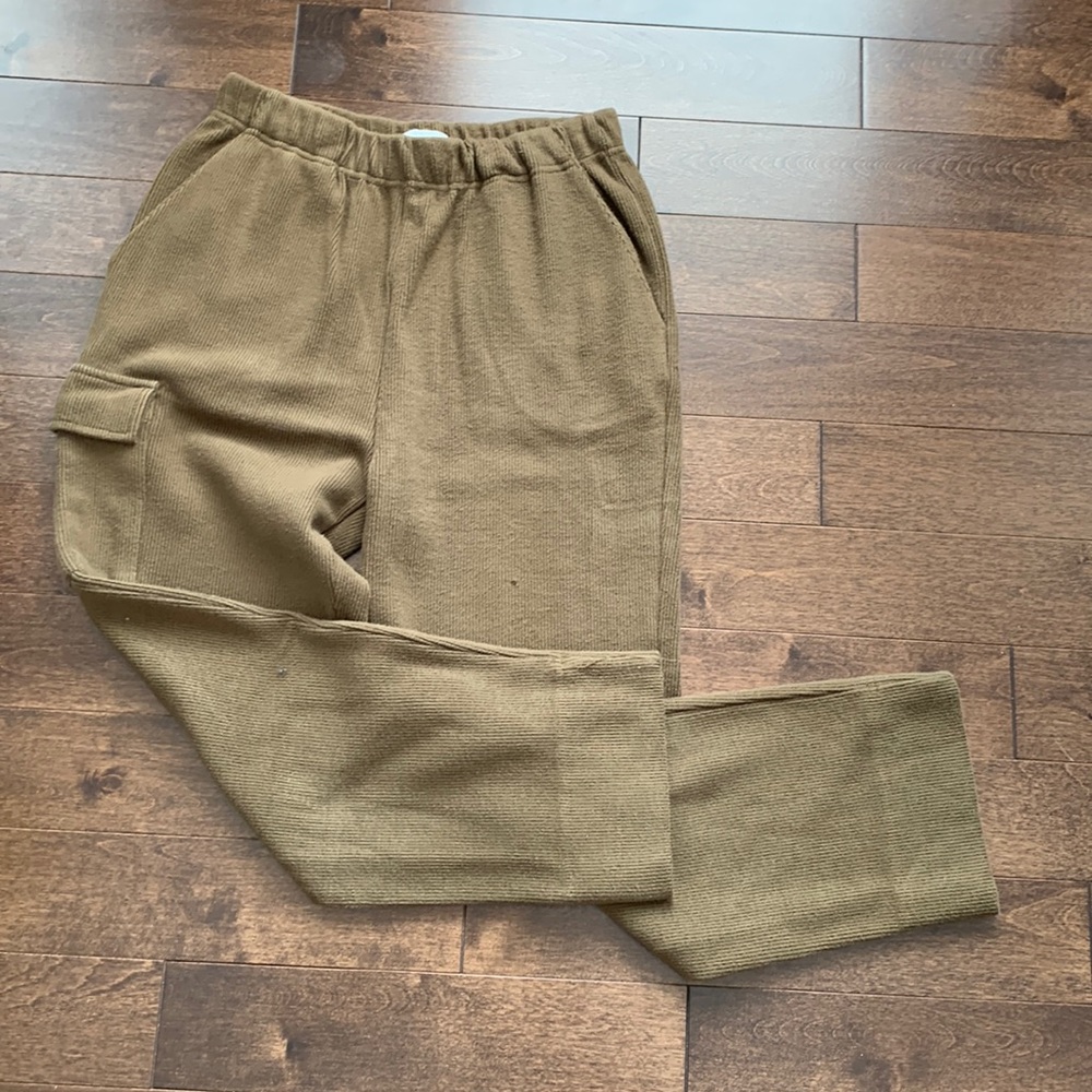 Olive green elastic waist pants with cargo style pocket on right leg